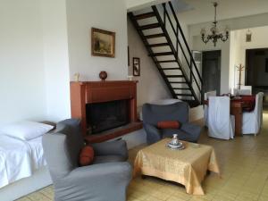 a living room with two chairs and a fireplace at 160 m2 village house "Arkadi" in Khárkia