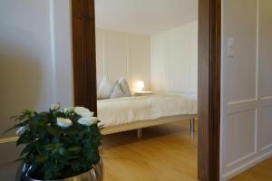 1 dormitorio con 1 cama y un jarrón con flores en Haus zur Rose, St.Gallen, Bodensee, Säntis en Speicher