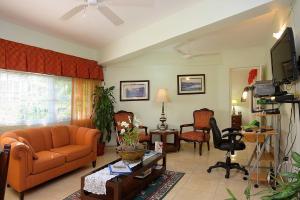 a living room with an orange couch and chairs at Kingston Cottage in Kingston