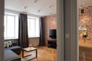 sala de estar con sofá y pared de ladrillo en Red Brick Old Town Apartment, en Varsovia