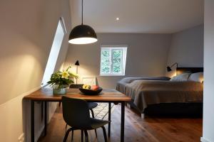 Habitación con mesa, cama y dormitorio. en Guesthouse Bärenbad, en Staufen