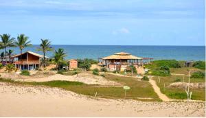 a resort on the beach with the ocean in the background at Pousada Vila Mar in Itaúnas