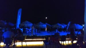 a group of people sitting in chairs at night at Linamare Eolos in Kiveri
