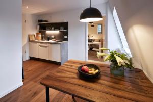 a room with a wooden table with a bowl of fruit on it at Guesthouse Bärenbad in Staufen im Breisgau