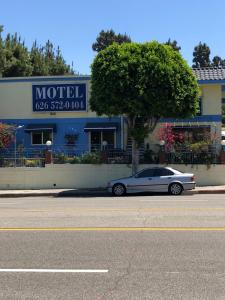 een zilveren auto geparkeerd voor een motel bij King Lodge Motel in Monterey Park