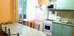 モスクワにあるApartments at Volgogradskiy prospektのキッチン(白い冷蔵庫、テーブル、椅子付)
