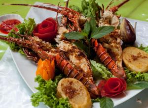 um prato de comida com lagosta e legumes numa mesa em Mamaqocha em Canoas de Punta Sal