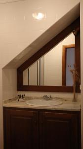 un bagno con lavandino e specchio di Casa Dona Urraca a Vilarinho da Castanheira