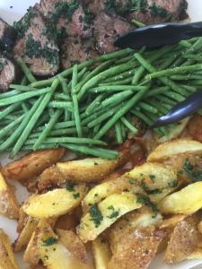 un plato de comida con patatas y judías verdes en Bella Vista Resort, en Naguilian