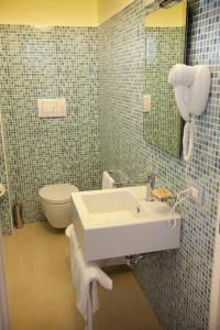 a bathroom with a sink and a toilet and a mirror at Sunset Beach in Marausa