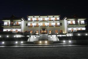 a large white building at night with lights at Villa Belles in Akritochori