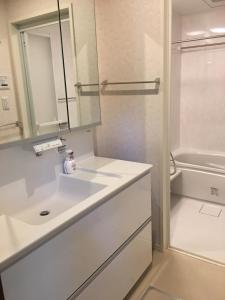 a white bathroom with a sink and a tub at Kyoto LanLan in Kyoto