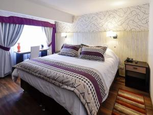 um quarto com uma cama grande e uma janela em LV Hoteles Boutique em Viña del Mar