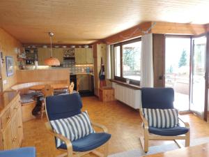 eine Küche mit zwei blauen Stühlen und einem Tisch in der Unterkunft Barlangia (455 Ho) in Valbella