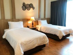 a hotel room with two beds and a window at Civilize Hotel in Udon Thani