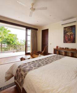 Un dormitorio con una cama grande y una ventana grande. en Villa Ali Agung, en Uluwatu 30 fotos más