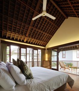 Un dormitorio con una cama con ventilador de techo. en Villa Ali Agung, en Uluwatu