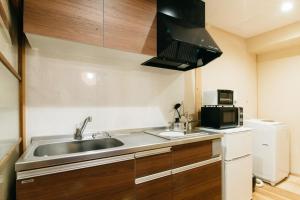 a small kitchen with a sink and a microwave at Tenjin TABI-NE in Kanazawa
