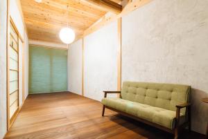 uma sala de estar com um sofá verde no canto em Tenjin TABI-NE em Kanazawa