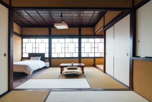 um quarto com uma cama e uma mesa em Tenjin TABI-NE em Kanazawa