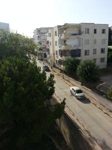 a white car parked on a street with buildings at La perle de Kouba lacroix in Alger