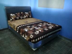 a bed in a room with a blue wall at Olivia homestay in Banyuwangi