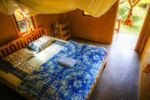 a bedroom with a bed with a blue blanket at Family Hut Pai in Pai