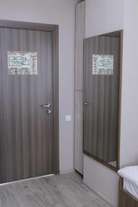 Zimmer mit Holztür und Spiegel in der Unterkunft Гостиница CARE in Krasnojarsk
