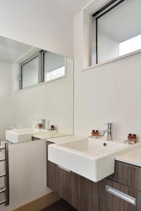 a bathroom with a white sink and a mirror at Armagh Apartment 3 - Christchurch Holiday Homes in Christchurch