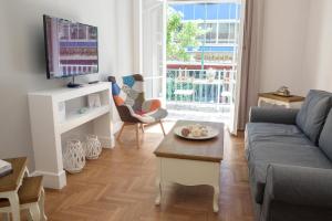 een woonkamer met een bank en een tv bij Elegant 2BD Apartment in the heart of Athens in Athene