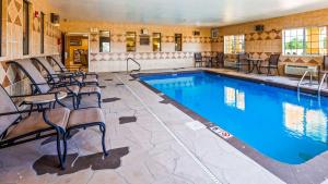 a pool with chairs and tables and a swimming pool at Best Western Parsons Inn in Parsons