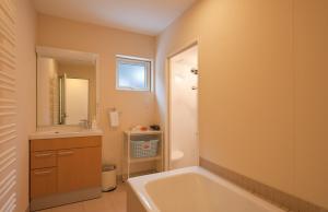 a bathroom with a tub and a sink and a mirror at Nichigo in Kutchan +13 photos