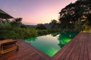 a swimming pool on a wooden deck with a bench at Kings Pavilion Luxury Hotel in Kandy