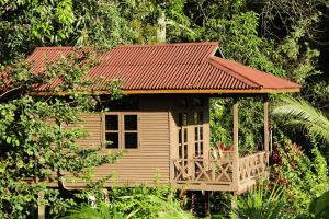 una pequeña casa en el árbol con techo rojo en Sepilok Forest Edge Resort, en Sepilok
