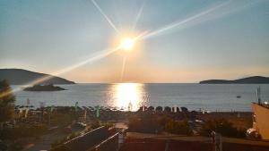 a view of a beach with the sun setting over the water at Leonidas Apartments in Nea Peramos