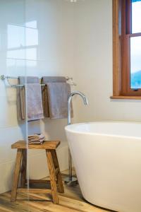 a bathroom with a white tub and a window and towels at Flinders Bush Retreats in Hawker
