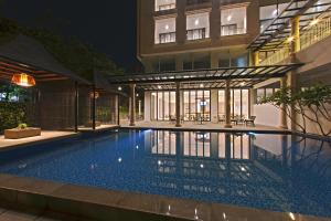 - une piscine en face d'un bâtiment la nuit dans l'établissement Royal Padjadjaran Hotel, à Bogor