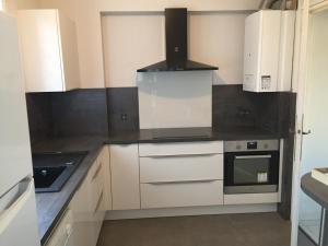 a kitchen with white cabinets and a stove at SETE - 6 Quai Louis Pasteur in Sète