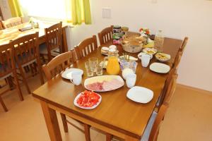 una mesa de madera con platos de comida. en Penzion Ječmínek, en Červená Voda