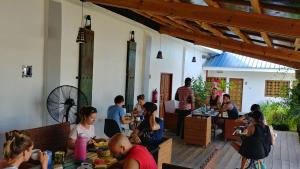 een groep mensen die aan tafel zitten in een restaurant bij Nungwi House in Nungwi
