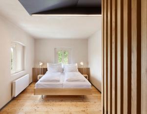 a bedroom with a bed with white sheets and a window at Hotel Kleis in Cvikov