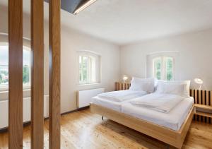 a white bedroom with a large bed with white sheets at Hotel Kleis in Cvikov