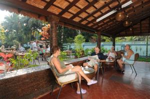 un grupo de personas sentadas en sillas en un restaurante en Osborne Holiday Resorts, en Calangute