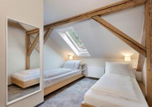 two beds in a small room with a window at Hotel Kleis in Cvikov