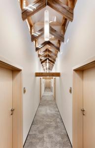 a hallway with wooden ceilings and a hallway lined with doors at Hotel Kleis in Cvikov