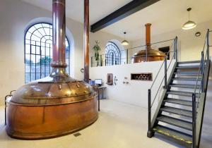 a large wine barrel in a room with a staircase at Hotel Kleis in Cvikov