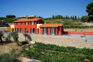 een rood huis met een oranje dak op een heuvel bij Poggio dei Gorleri in Diano Marina