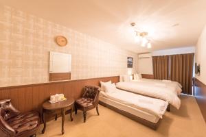 une chambre d'hôtel avec un lit et une chaise dans l'établissement Floral Green Maple House, à Kyoto