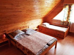 1 dormitorio con 2 camas en una cabaña de madera en Viesu nams Barži, en Tīnūži