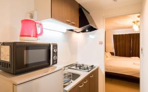 Il comprend une petite cuisine avec un four micro-ondes et une cuisine avec un lit. dans l'établissement Floral Green Maple House, à Kyoto